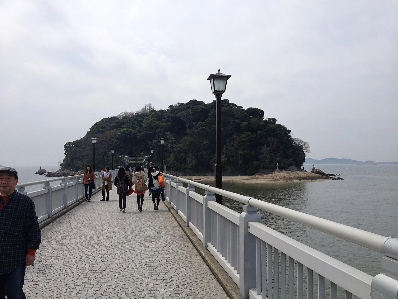 海の上に伸びる竹島橋を歩く人々
